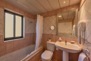 a bathroom with a sink and a toilet and a tub at Grand Hotel Gozo in Għajnsielem