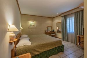 a hotel room with a bed and a window at Grand Hotel Gozo in Għajnsielem