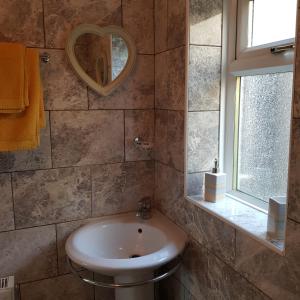 uma casa de banho com um lavatório e um espelho em Chynoweth Court em Newquay