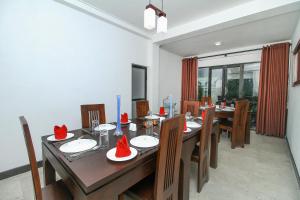 a dining room with a wooden table and chairs at Delphin Hotel in Nuwara Eliya