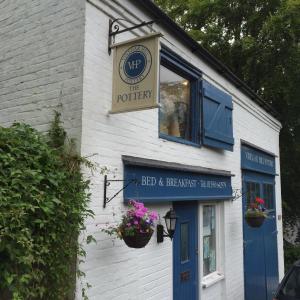 a building with a sign for a bed and breakfast exchange at Vinegar Hill Pottery in Lymington