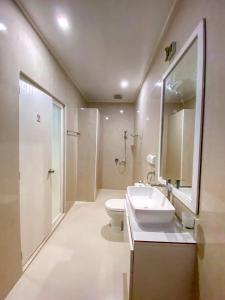 bagno con lavandino, servizi igienici e specchio di Hevana holidays a Felidhoo 