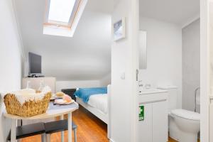 una camera con un letto e un tavolo con un cesto di Porta 34 Apartments a Braga Altre 70 foto