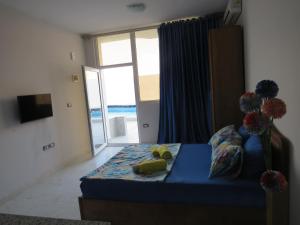 Apartment Stella di Mari near the sea RedSeaLine في الغردقة: غرفة نوم بسرير ازرق مطلة على المحيط