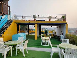 a patio with tables and chairs on a roof at Hotel Rashmi in Agra