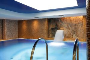 eine große blaue Badewanne in einem Zimmer mit einer Wand in der Unterkunft Aqua Marina in Karlsbad