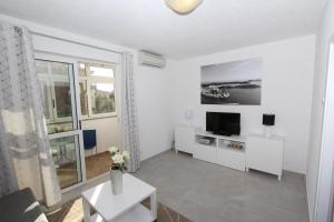 Biały salon z telewizorem i kanapą w obiekcie Apartment Stellina w Rovinj