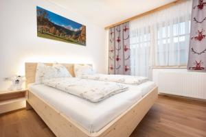 een bed in een kamer met een raam bij Haus Alpenruhe by Schladmingurlaub in Ramsau am Dachstein