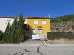une maison jaune sur le côté d'une route dans l'établissement Casa rural LAS TABLAS, à Riópar