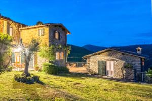 an old stone house in a field with mountains in the background at Agriturismo La Sala in Greve in Chianti