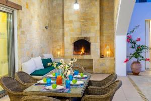 a living room with a table and a fireplace at Villa Zoe in Miliou