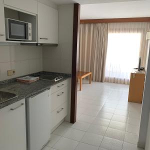 a kitchen with a sink and a microwave at Apartamentos Marina in Port de Pollensa +15 photos