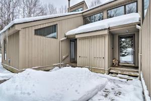 a house with snow on the ground in front of it at Cozy Condo Steps to Lake Michigan, 5 Mi to Boyne! in Harbor Springs
