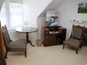 a room with a table and two chairs and a mirror at Mackenzie House in Kirkcudbright