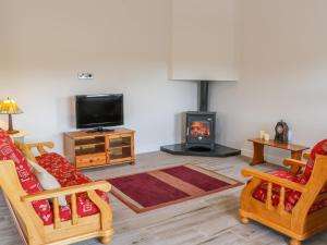 a living room with two chairs and a fireplace at River Dale in Willsborough