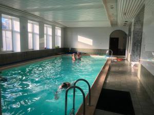two people swimming in a swimming pool at Hotel Sabina in Riga