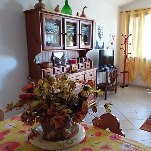 una stanza con tavolo e vaso di fiori di Casa vacanze Antonella Pula a 750mt dal centro. a Pula