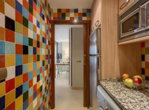 a kitchen with a sink, a refrigerator, and a window at Apartamentos Suites Oficentro in Málaga