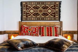 a bed with two large pillows and a headboard at Rahat Hotel in Arkhyz