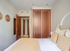 1 dormitorio con 1 cama y puerta de madera en Apartamentos Suites Oficentro, en Málaga