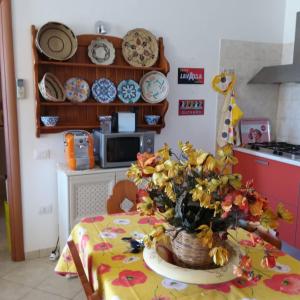 una cucina con tavolo e vaso di fiori di Casa vacanze Antonella Pula a 750mt dal centro. a Pula