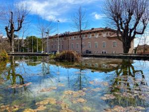 a pond of water with trees and a building at Hotel Berga Park in Berga