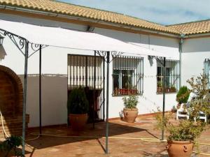 una tienda blanca frente a una casa con macetas en Casa Cantarrana, en Arriate