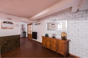 a kitchen with a wooden cabinet and a white brick wall at El Ciervo in Sierra Nevada