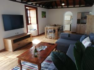 sala de estar con sofá azul y mesa en Los Frailes en Breña Baja