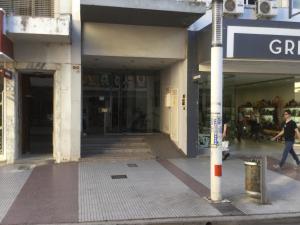 Un homme marchant dans une rue en face d'un magasin dans l'établissement Bahía x día 1, à Bahía Blanca