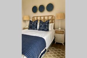 um quarto com uma cama com lençóis e almofadas azuis e brancas em 1B Sugar Crest , Umdloti Beach em Umdloti