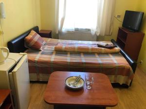een kleine hotelkamer met een bed en een tafel bij Hotel Sabina in Rīga