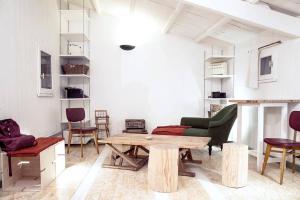 a living room with a wooden table and chairs at Logement Design à Loix-en-Ré - 2 étoiles - Centre Village in Loix