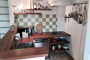 a small kitchen with a sink and a stove at Logement Design à Loix-en-Ré - 2 étoiles - Centre Village in Loix +8 photos