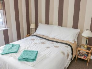Glor Cottage في باليهاونيس: غرفة نوم عليها سرير وفوط