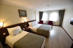 Un pat sau paturi într-o cameră la Asal Hotel
