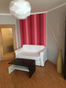 a living room with a white couch and a striped wall at Apartmán Edita in Velké Losiny