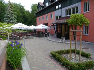 une cour avec des tables et des chaises devant un bâtiment dans l'établissement Akzent Berghotel Rosstrappe, à Thale