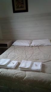 two white towels sitting on top of a bed at Hotel Vison in Jarinu