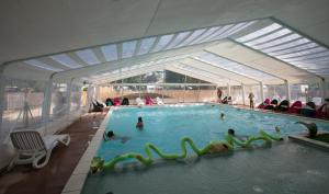 a swimming pool with people in the water at Camping La Belle Etoile in Melun