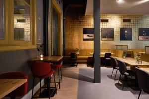 a restaurant with tables and chairs in a room at Hotel Mariënhage in Eindhoven