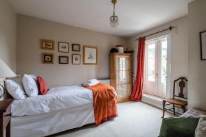 Un dormitorio con una cama con una manta naranja. en Charming Chiswick Home near Ravenscourt Park by UndertheDoormat, en Londres