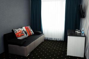 ein Sofa mit Kissen darauf in einem Zimmer mit Fenster in der Unterkunft River Park hotel in Kowel