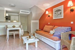 a living room with a couch and a table at Résidence Pierre & Vacances le Hameau de la Pinède in Hyères