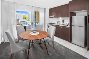 a kitchen and dining room with a table and chairs at 2-Bed Near Brisbane CBD with Pool, Sauna & BBQ in Brisbane