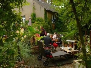 um grupo de pessoas sentadas num jardim em Haus im grünen - Hürth em Fischenich