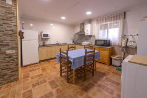 a kitchen with a table and a white refrigerator at Casa rural LAS TABLAS in Riópar