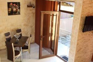 a dining room with a table and a glass door at KOTEJ UREKI in Ureki