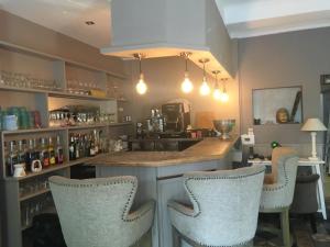 a bar with two chairs and a counter in a room at Les 2 grives - auberge restaurant in Bras-dʼAsse