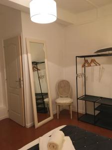 uma sala de estar com um espelho e uma cadeira em Auberge De Marie em Bras-dʼAsse